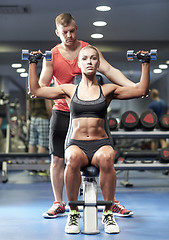 Image showing man and woman with dumbbells in gym