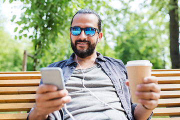 Image showing man with earphones and smartphone drinking coffee