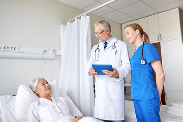 Image showing doctor and nurse visiting senior woman at hospital