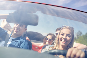 Image showing happy friends driving in cabriolet car