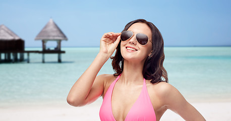 Image showing happy woman in sunglasses and bikini on beach