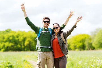 Image showing happy couple with backpacks hiking outdoors