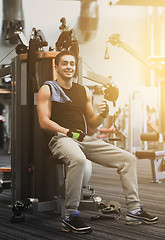Image showing smiling man exercising on gym machine