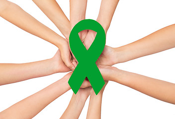 Image showing close up of hands with green awareness ribbon