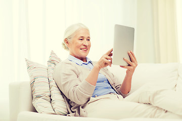 Image showing happy senior woman with tablet pc at home