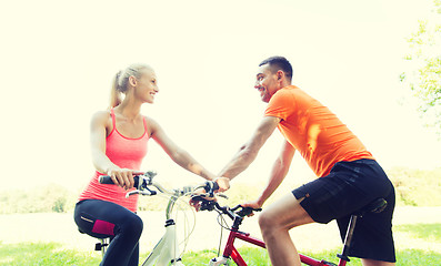 Image showing happy couple riding bicycle outdoors