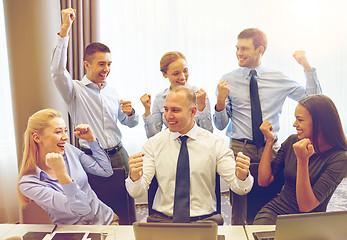 Image showing business people celebrating victory in office