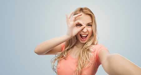 Image showing happy smiling young woman taking selfie