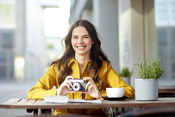 Image showing happy tourist woman with camera at city cafe