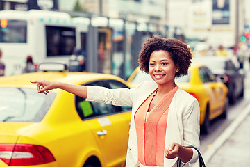 Image showing happy african woman catching taxi