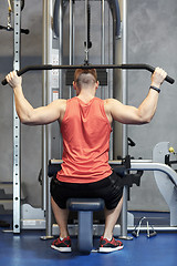 Image showing man flexing muscles on cable machine gym