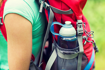 Image showing close up of woman with water bottle in backpack