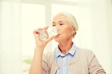 Image showing happy senior woman with glass of water at home