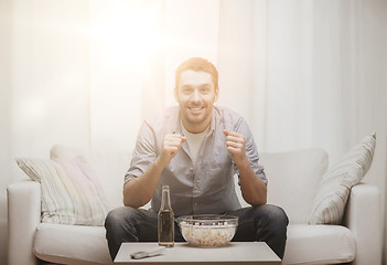 Image showing smiling man watching sports at home