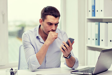 Image showing businessman with smartphone and laptop at office