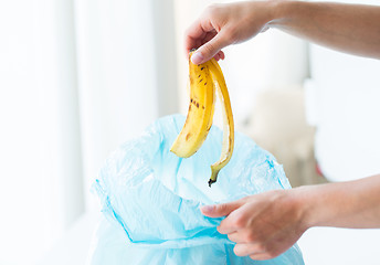 Image showing close up of hand putting food waste to rubbish bag