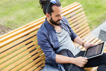 Image showing man with tablet pc sitting on city street bench