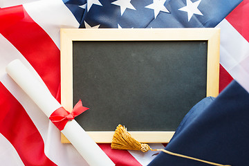 Image showing board, bachelor hat and diploma on american flag