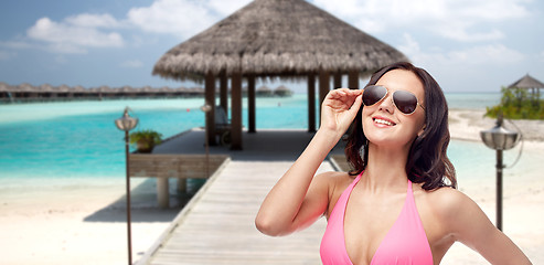 Image showing happy woman in sunglasses and bikini on beach