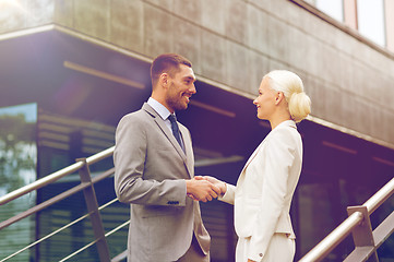 Image showing smiling businessmen shaking hands on street