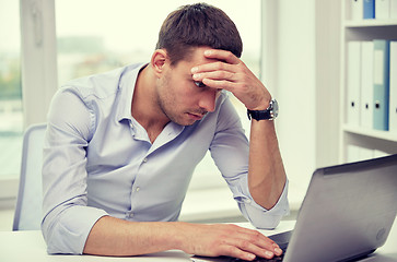 Image showing stressed businessman with laptop at office