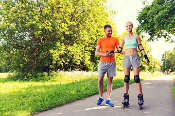 Image showing happy couple with roller skates riding outdoors