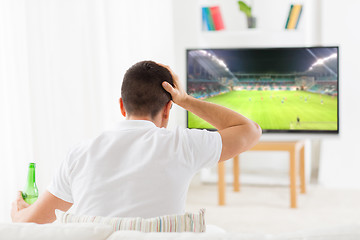 Image showing man watching football or soccer game on tv at home