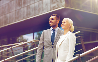 Image showing smiling businessmen standing over office building