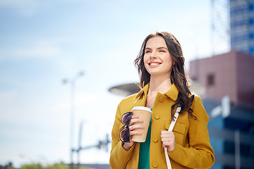 Image showing happy young woman drinking coffee on city street