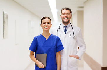 Image showing smiling doctor in white coat and nurse at hospital