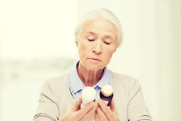 Image showing senior woman with medicine jars at home