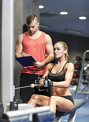 Image showing man and woman flexing muscles on gym machine