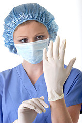 Image showing Lady surgeon putting on gloves