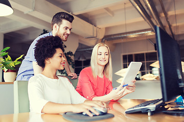 Image showing happy creative team with computer in office