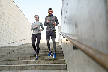 Image showing happy couple running downstairs in city