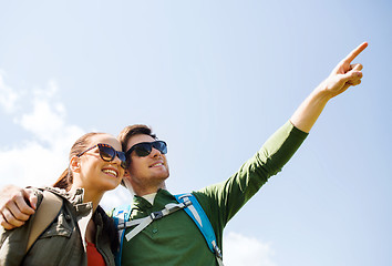 Image showing happy couple with backpacks hiking outdoors