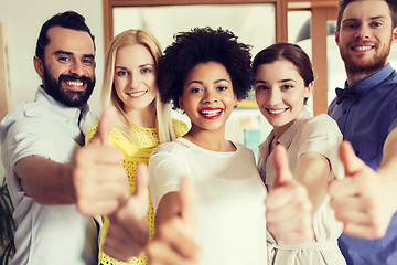 Image showing happy creative team showing thumbs up in office