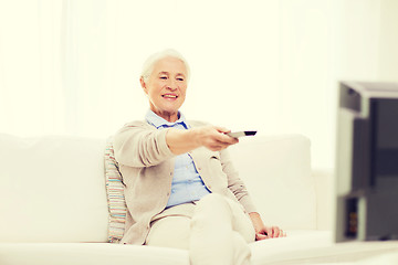 Image showing happy senior woman watching tv at home