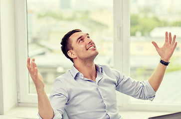 Image showing happy businessman with laptop in office