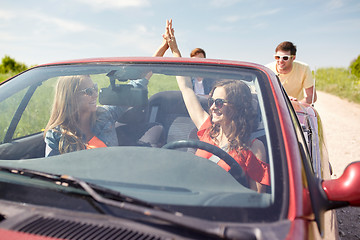 Image showing happy friends pushing broken cabriolet car