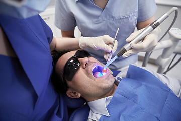 Image showing dentists treating male patient teeth at clinic