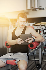 Image showing young man with tablet pc computer in gym