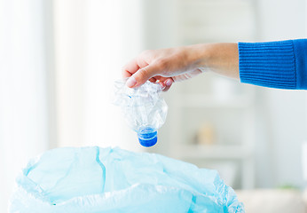 Image showing close up of hand and used bottles in rubbish bag