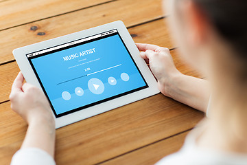 Image showing close up of woman with tablet pc on wooden table