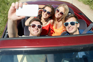 Image showing friends driving in cabriolet car and taking selfie