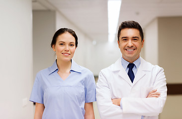 Image showing smiling doctor in white coat and nurse at hospital