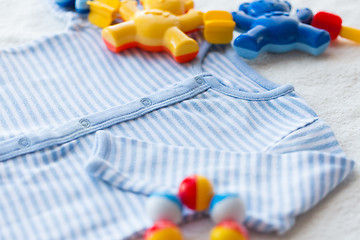 Image showing close up of baby bodysuit for newborn and rattle