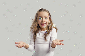 Image showing Girl playing with soap bubbles