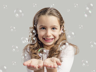 Image showing Girl playing with soap bubbles