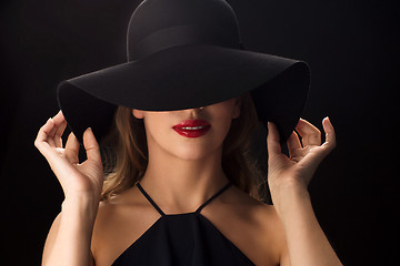 Image showing beautiful woman in black hat over dark background